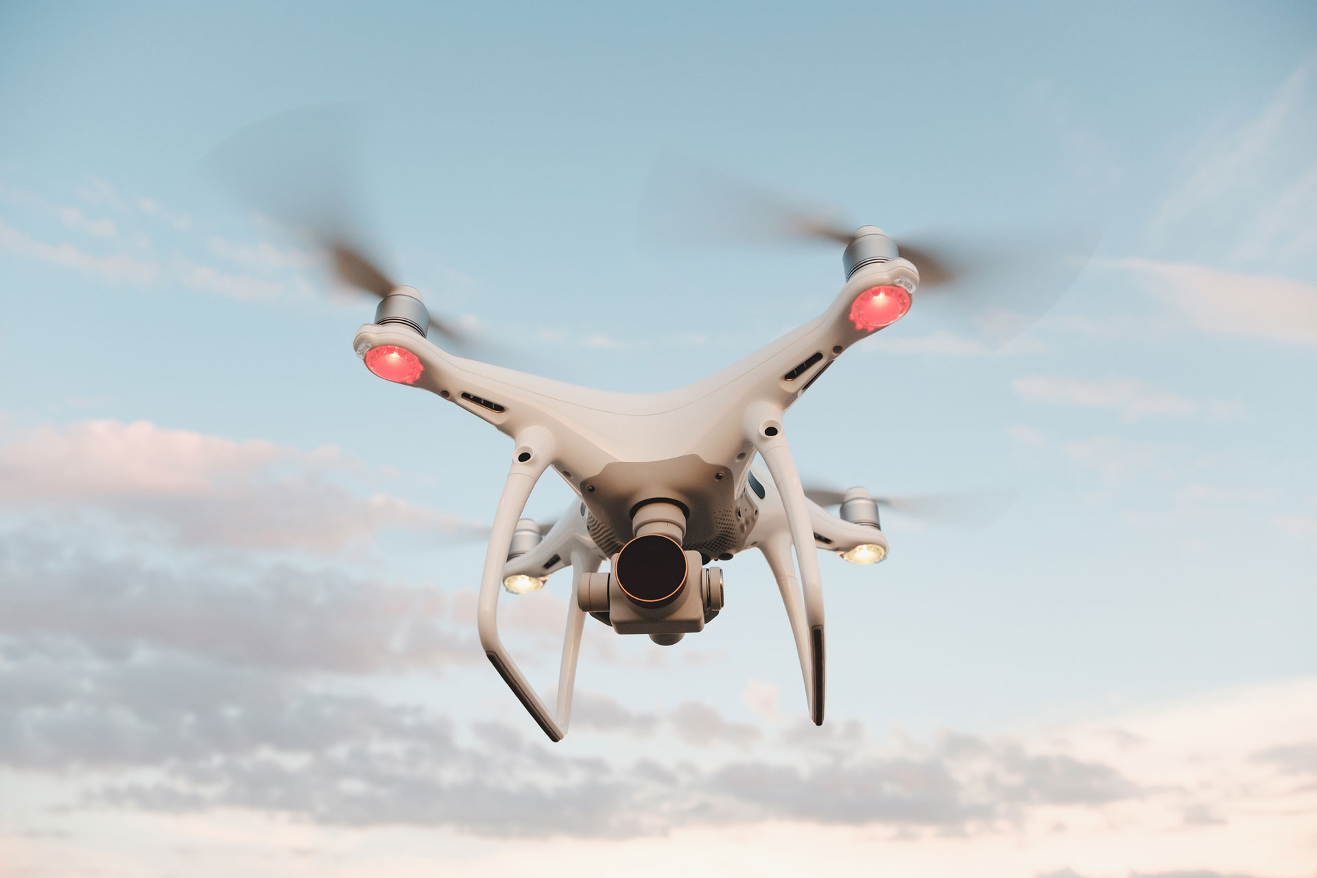 white-drone-hovering-in-a-bright-blue-sky-PMFRLG7.jpg